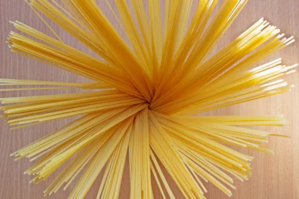 テーブルの上の瓶の中に調理されていないイタリアのスパゲティ テーブルの上に黄色の長いスパゲティファン イタリアのパスタ 食品コンセプトの背景 イタリア料理とメニューのコンセプト — ストック写真