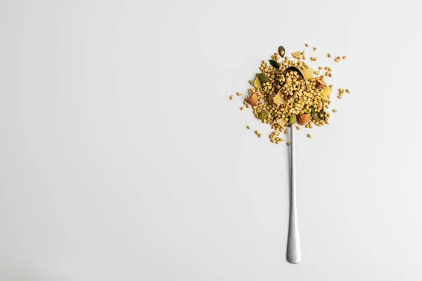 Granola with green buckwheat, nuts and coconut on a spoon on a white background. Healthy food concept. Food for breakfast and snack. — Stock Photo, Image