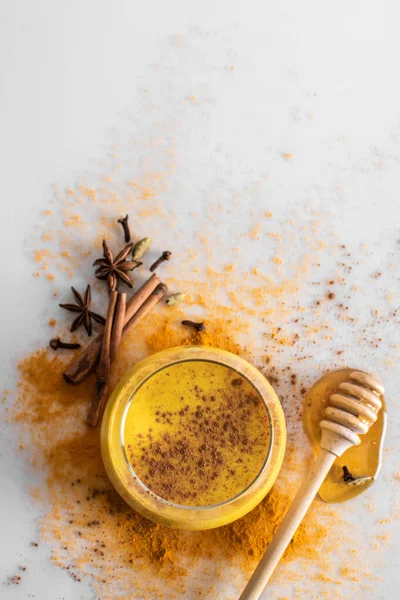 Leche dorada con cúrcuma en polvo en un vaso sobre un fondo claro, copia el espacio. Disparando desde arriba. Salud y energía, remedio contra la gripe. Comida limpia, desintoxicación, concepto de pérdida de peso . —  Fotos de Stock