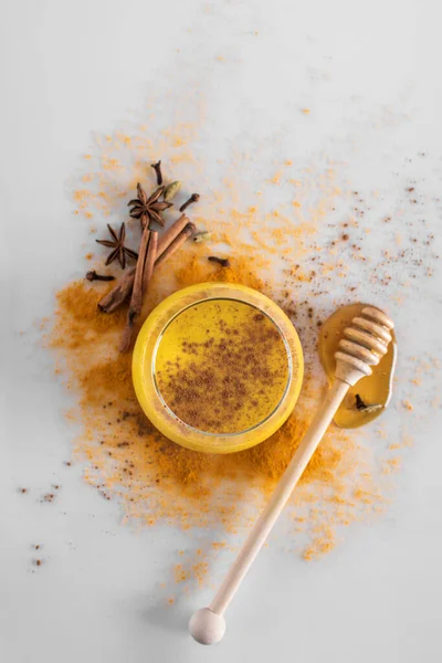 Golden milk with turmeric powder in a glass on a light background, copy space. Health and energy, anti-flu, natural fighting drink. Clean food, detox, weight loss concept. — Stock Photo, Image