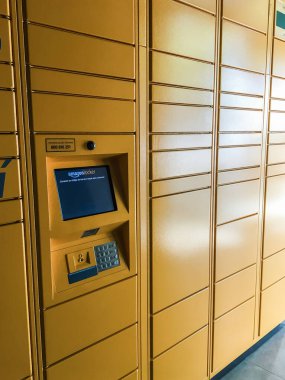 Alışveriş merkezindeki Amazon dolabı, üzerinde Amazon markası logosu olan posta siparişleri için turuncu nokta. Sabadell, İspanya - 9 Nisan 2020