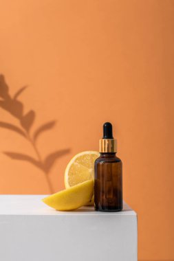 Cilt bakımı için pipetli cam kahverengi serum şişesi. Limonlar ve taze otlar. Doğrudan aydınlatma, ışığın ve gölgenin karşıtlığı. Sağlık ve güzellik kavramı. minimalizm, boşluğu kopyala