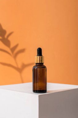 Cilt bakımı için pipetli cam kahverengi serum şişesi. Doğrudan aydınlatma, ışığın ve gölgenin karşıtlığı. Sağlık ve güzellik kavramı. minimalizm