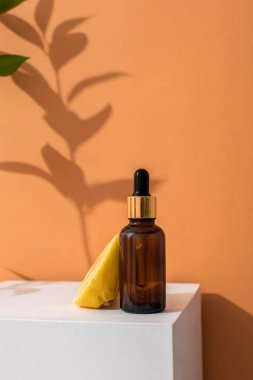 Cilt bakımı için pipetli cam kahverengi serum şişesi. Limonlar ve taze otlar. Doğrudan aydınlatma, ışığın ve gölgenin karşıtlığı. Sağlık ve güzellik kavramı. minimalizm, boşluğu kopyala