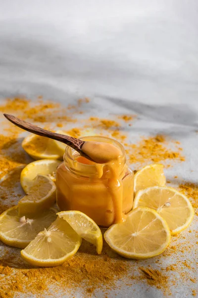 Kavanozda manuka balı, arka planda limon ve zerdeçal. Alternatif tıp konsepti. Süper yemek. Boşluğu kopyala