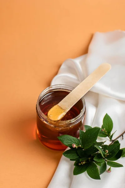 Güzellik ve tüy dökme kavramı. Sıcak bir arka plandaki saçı temizlemek için şekerli bir kap, üst manzara. Spa ve Shugaring.