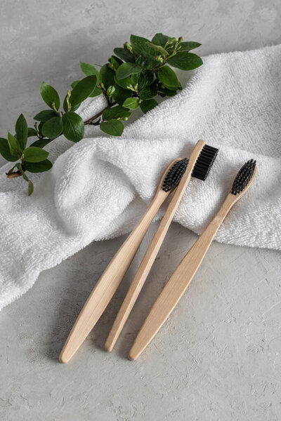 Several bamboo toothbrushes on a white towel. The concept of beauty and health about yourself. Zero West