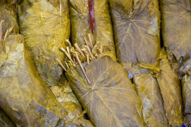 Turşulu üzüm yaprakları. Doğu pazarının tezgahında geleneksel doğu yemekleri ve atıştırmalıkları hazırlamak için üzüm yaprakları.