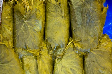 Turşulu üzüm yaprakları. Doğu pazarının tezgahında geleneksel doğu yemekleri ve atıştırmalıkları hazırlamak için üzüm yaprakları.