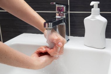 Kadın ellerini sabunla yıkıyor. El yıkamayı doğru dürüst öğreten tanınmamış bir kadın. Coronavirus veya COVID-19 önleme
