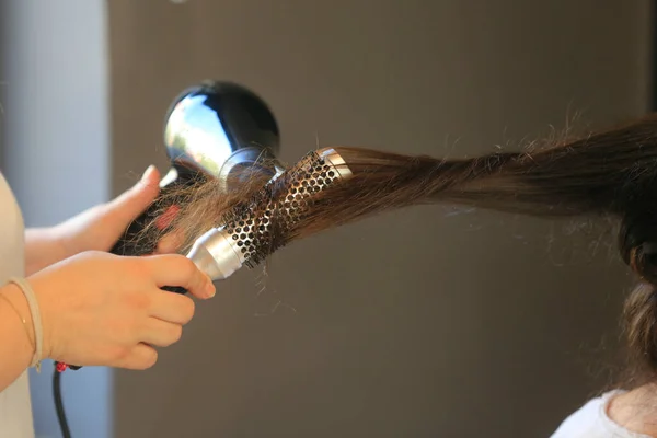 Hairdresser dries the hair in a beauty salo
