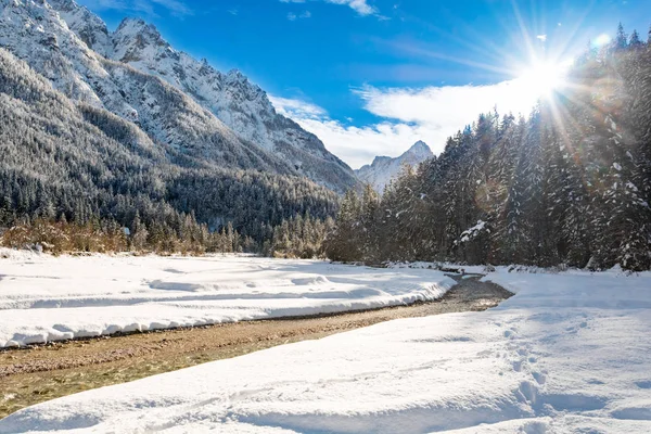 晴れた冬の日の背景の山と Pisnica クリークと設定日 — ストック写真
