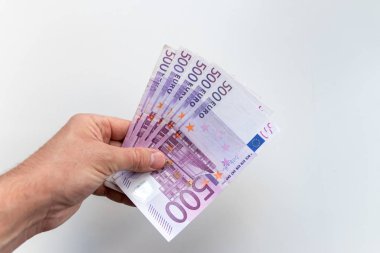Avrupa ve Avrupa 'daki uluslararası ticaret ve finans piyasasını gösteren bulanık beyaz bir geçmişe sahip, ödül, kredi veya yan iş olarak avro banknotları tutan Avrupalı bir adamın eli