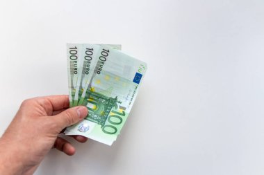 Avrupa ve Avrupa 'daki uluslararası ticaret ve finans piyasasını gösteren bulanık beyaz bir geçmişe sahip, ödül, kredi veya yan iş olarak avro banknotları tutan Avrupalı bir adamın eli