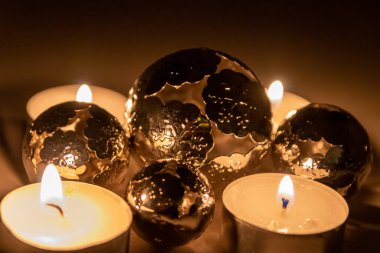 Noel mumlarının romantik mum ışıkları Noel arifesinden önceki gece ve sonraki zaman boyunca pırıl pırıl parlayan metal toplar şeklinde Noel süslemeleri.