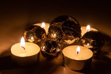 Noel mumlarının romantik mum ışıkları Noel arifesinden önceki gece ve sonraki zaman boyunca pırıl pırıl parlayan metal toplar şeklinde Noel süslemeleri.