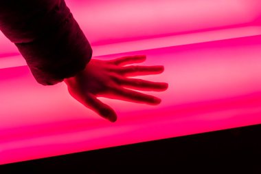 Yakından - pembe bir ışık tutan bir adamın el görüntüsü