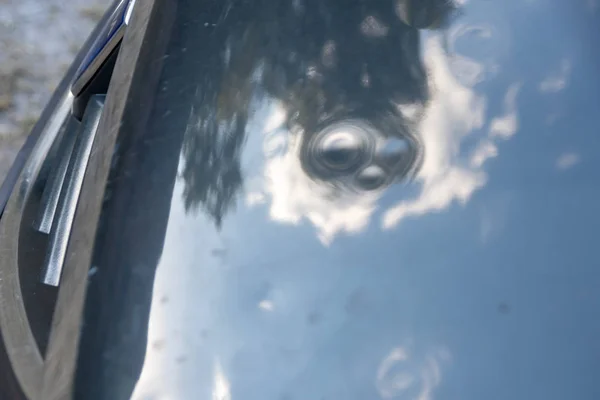 Car engine hood with many hail damage dents show the forces of nature and the importance of car insurance and a replacement value insurance against stormy weather and storm hazards