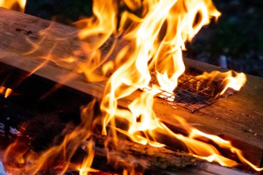 Shiny burning fire in the dark shows the romantic side of a campfire or bonfire, fire safety and the need of a fire insurance as well as survival adventures outdoor with the children and the family