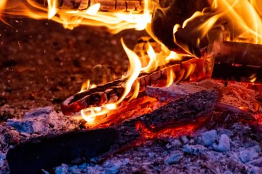 Shiny burning fire in the dark shows the romantic side of a campfire or bonfire, fire safety and the need of a fire insurance as well as survival adventures outdoor with the children and the family