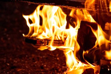 Shiny burning fire in the dark shows the romantic side of a campfire or bonfire, fire safety and the need of a fire insurance as well as survival adventures outdoor with the children and the family