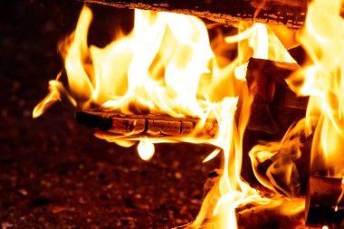 Shiny burning fire in the dark shows the romantic side of a campfire or bonfire, fire safety and the need of a fire insurance as well as survival adventures outdoor with the children and the family