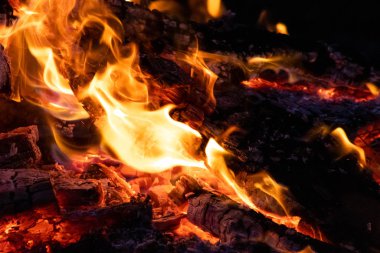 Shiny burning fire in the dark shows the romantic side of a campfire or bonfire, fire safety and the need of a fire insurance as well as survival adventures outdoor with the children and the family