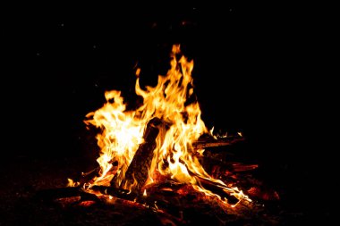 Shiny burning fire in the dark shows the romantic side of a campfire or bonfire, fire safety and the need of a fire insurance as well as survival adventures outdoor with the children and the family