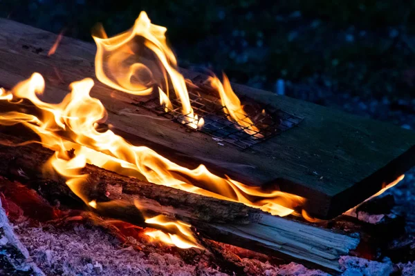 Shiny burning fire in the dark shows the romantic side of a campfire or bonfire, fire safety and the need of a fire insurance as well as survival adventures outdoor with the children and the family