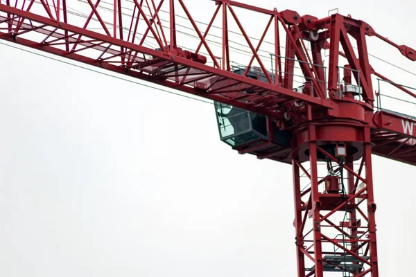 Big crane with heavy load transports construction material on a construction site for site supervisors and site managers to raise a building and create new architecture in city development and construction development