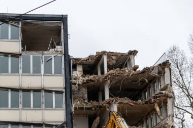 İnşaat ekipmanları kentsel mimariyi bozuk sanayi ile yeniden inşa ederken, şehirde buldozerler ve hidrolik kazıcı gibi ağır makinelerle bir inşaat alanının yıkılması