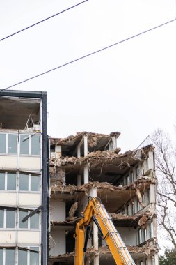 İnşaat ekipmanları kentsel mimariyi bozuk sanayi ile yeniden inşa ederken, şehirde buldozerler ve hidrolik kazıcı gibi ağır makinelerle bir inşaat alanının yıkılması