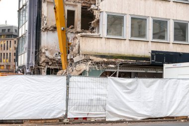 İnşaat ekipmanları kentsel mimariyi bozuk sanayi ile yeniden inşa ederken, şehirde buldozerler ve hidrolik kazıcı gibi ağır makinelerle bir inşaat alanının yıkılması