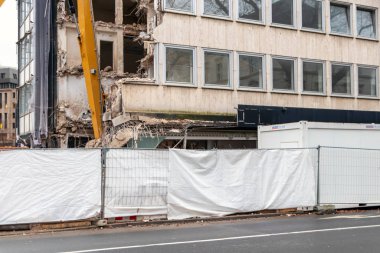 İnşaat ekipmanları kentsel mimariyi bozuk sanayi ile yeniden inşa ederken, şehirde buldozerler ve hidrolik kazıcı gibi ağır makinelerle bir inşaat alanının yıkılması