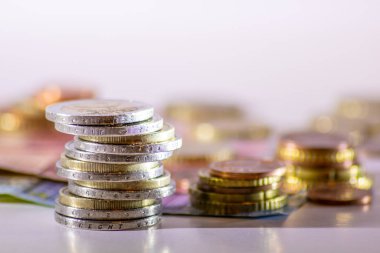 Arka plandaki Avrupa sikkeleri yığını ve banka notları, Avro ve Avrupa, Avrupa ticaret ve mali ticaretinin yanı sıra tasarruf, mali başarı ve kredi yönetimi ile uluslararası finansmanı gösteriyor