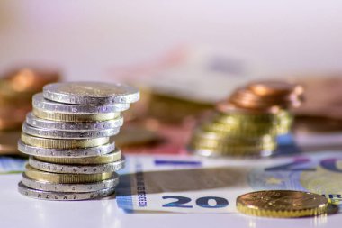 Arka plandaki Avrupa sikkeleri yığını ve banka notları, Avro ve Avrupa, Avrupa ticaret ve mali ticaretinin yanı sıra tasarruf, mali başarı ve kredi yönetimi ile uluslararası finansmanı gösteriyor