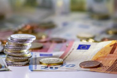 Arka plandaki Avrupa sikkeleri yığını ve banka notları, Avro ve Avrupa, Avrupa ticaret ve mali ticaretinin yanı sıra tasarruf, mali başarı ve kredi yönetimi ile uluslararası finansmanı gösteriyor