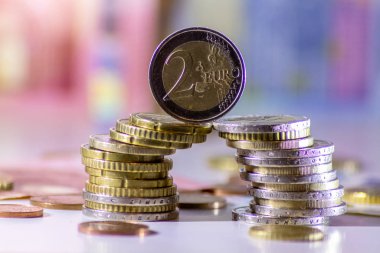Arka plandaki Avrupa sikkeleri yığını ve banka notları, Avro ve Avrupa, Avrupa ticaret ve mali ticaretinin yanı sıra tasarruf, mali başarı ve kredi yönetimi ile uluslararası finansmanı gösteriyor
