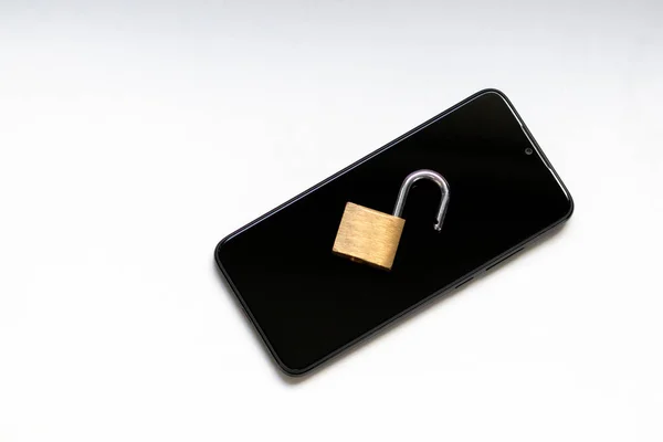 Vulnerable encryption and cyber security shows an open key lock on a black smartphone for hacker attack or cyber attack protection as safety in business and consumer market against hacker activities