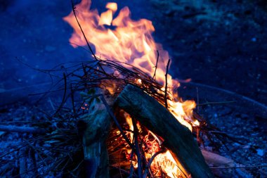 Shiny burning fire in the dark shows the romantic side of a campfire or bonfire, fire safety and the need of a fire insurance as well as survival adventures outdoor with the children and the family