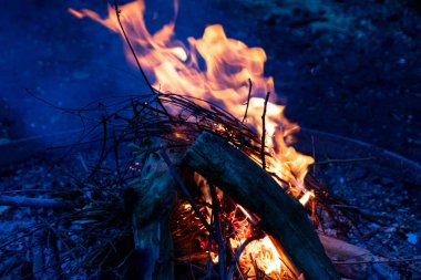 Shiny burning fire in the dark shows the romantic side of a campfire or bonfire, fire safety and the need of a fire insurance as well as survival adventures outdoor with the children and the family