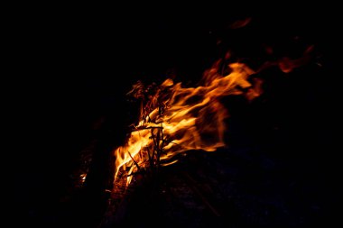 Shiny burning fire in the dark shows the romantic side of a campfire or bonfire, fire safety and the need of a fire insurance as well as survival adventures outdoor with the children and the family