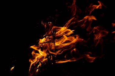 Shiny burning fire in the dark shows the romantic side of a campfire or bonfire, fire safety and the need of a fire insurance as well as survival adventures outdoor with the children and the family