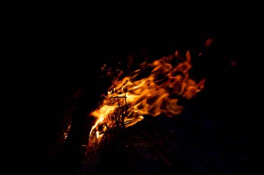 Shiny burning fire in the dark shows the romantic side of a campfire or bonfire, fire safety and the need of a fire insurance as well as survival adventures outdoor with the children and the family