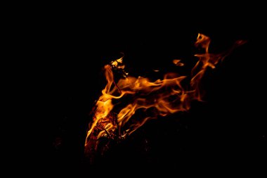 Shiny burning fire in the dark shows the romantic side of a campfire or bonfire, fire safety and the need of a fire insurance as well as survival adventures outdoor with the children and the family