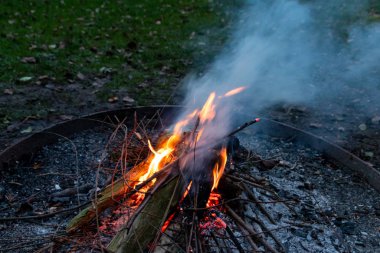 Shiny burning fire in the dark shows the romantic side of a campfire or bonfire, fire safety and the need of a fire insurance as well as survival adventures outdoor with the children and the family