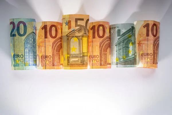 Different european bank notes illuminated as shiny bank note tubes with 50 euro, 20 euro, 10 euro and 5 euro show european money and european financial trade in the financial markets of europe