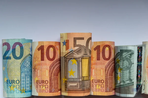 Different european bank notes rolled to bank note tubes show a 50 euro bank note, a 20 euro bank note, 10 euro and 5 euro and symbolize european financial market and international trade with europe