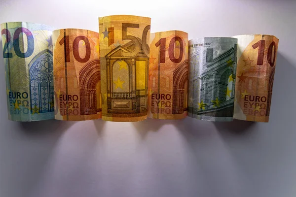 Different european bank notes illuminated as shiny bank note tubes with 50 euro, 20 euro, 10 euro and 5 euro show european money and european financial trade in the financial markets of europe