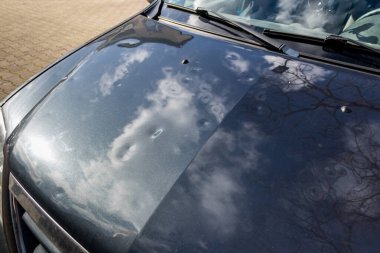 Dolu hasarı olan araba çatısı, doğa gücünü ve araba sigortasının önemini gösterir. Fırtınalı hava ve fırtına tehlikelerine karşı yeni bir değer sigortası.